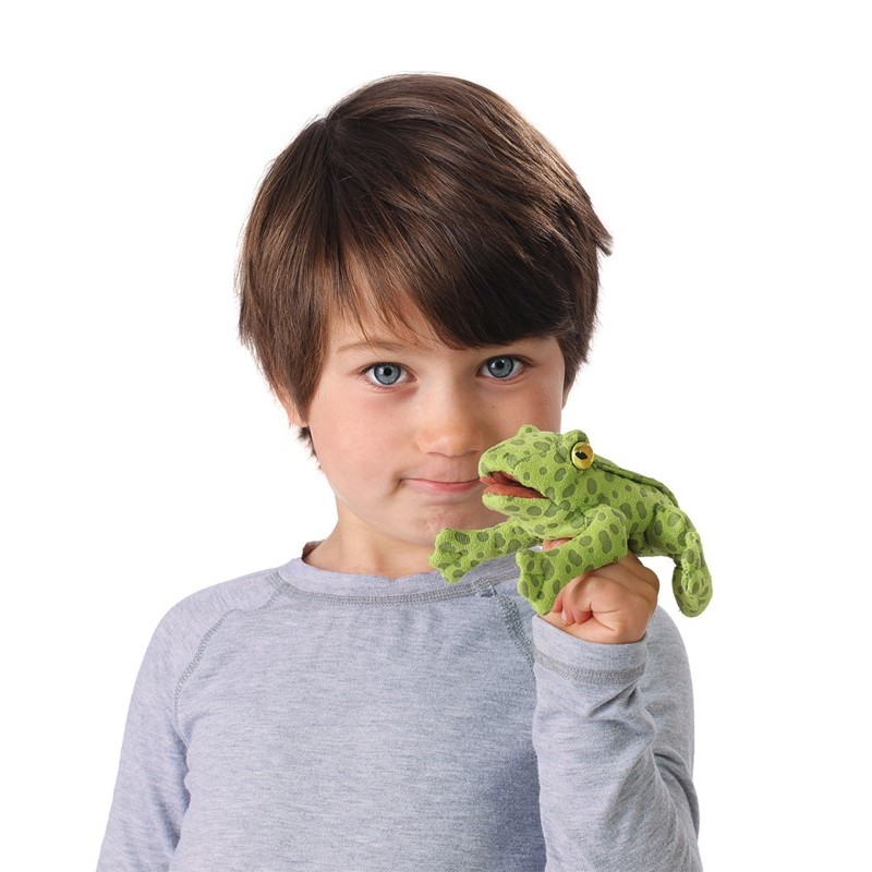 Boy holding a green spotted Folkmanis mini frog finger puppet on his index finger, with a yellow eye and movable mouth