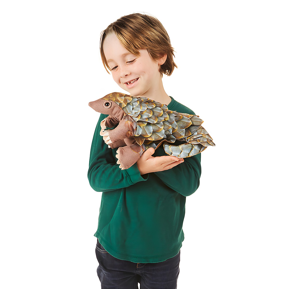 Boy holding a Folkmanis pangolin hand puppet with detailed brown and grey scales, side view