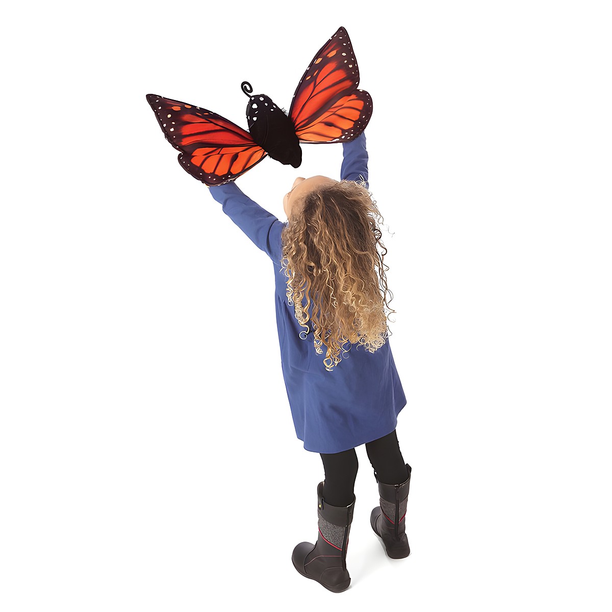 Girl holding a Folkmanis monarch butterfly hand puppet with orange-and-black patterned wings high up in the air