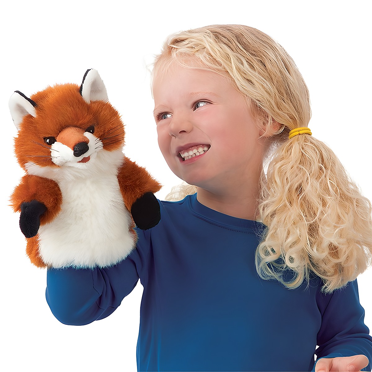 Girl smiling while holding up the Folkmanis Little Fox hand puppet with red-brown fur and white belly