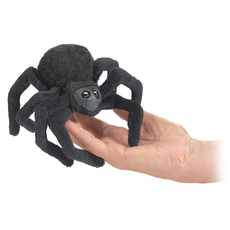 Folkmanis mini finger puppet spider in black with eight legs, sitting on a flat palm, close-up view