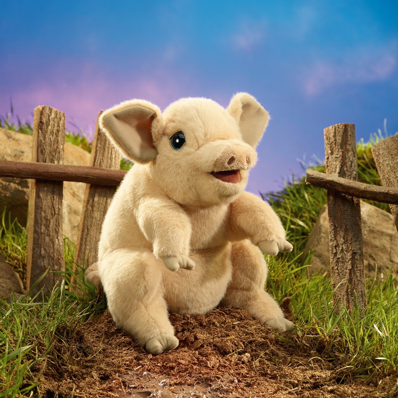 Folkmanis piglet hand puppet with open mouth and raised front paws, cream-coloured plush, side view in front of a wooden fence