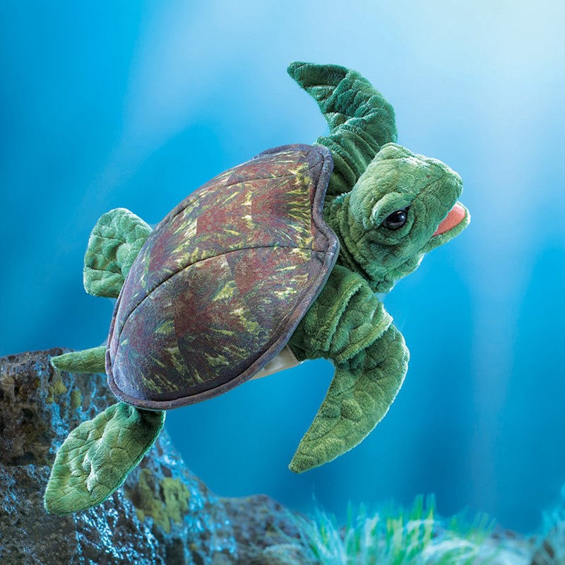 Folkmanis sea turtle hand puppet with a brown-green patterned shell and movable mouth, set against a blue underwater background