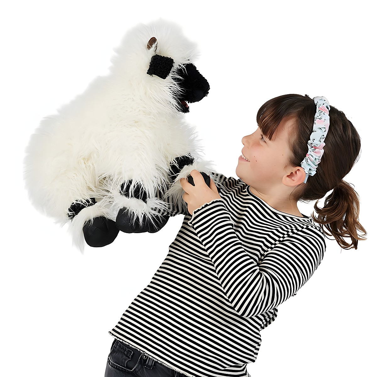 Girl holding up a Folkmanis hand puppet Valais Blacknose Sheep with white long-pile fur and black face mask