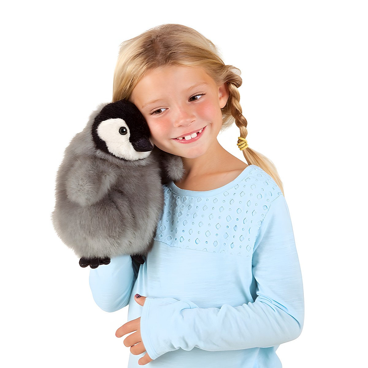 Mädchen hält Folkmanis Handpuppe Baby Kaiserpinguin mit grauem Plüschgefieder und weißem Gesicht an die Schulter
