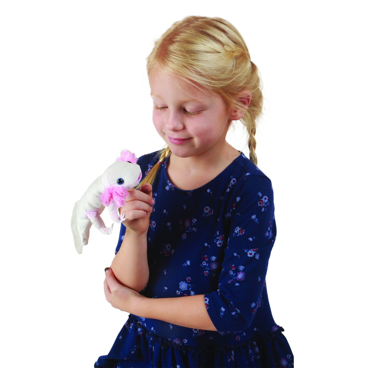 Mädchen hält Folkmanis Fingerpuppe Axolotl in Weiß mit rosa Kiemenbüscheln auf dem Zeigefinger und lächelt sie an.