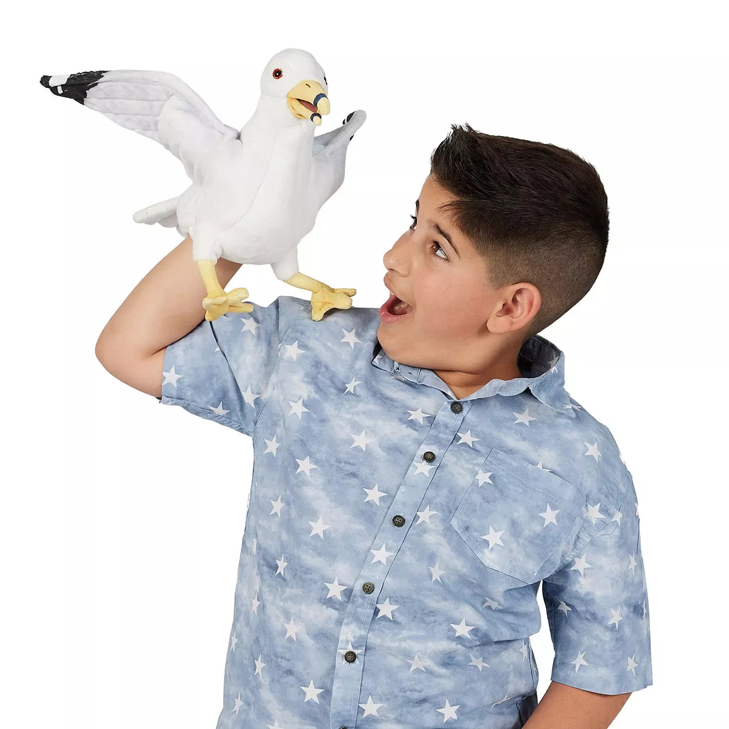 Boy holding a Folkmanis seagull hand puppet with spread wings on his fist, white plumage with black wingtips