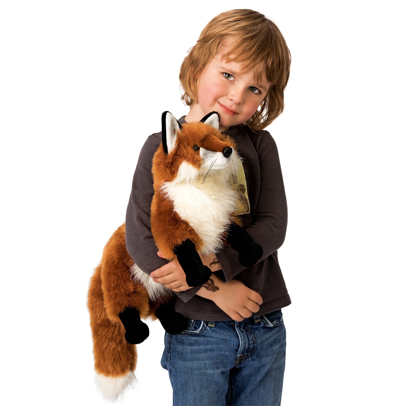 Child holding a large Folkmanis red fox hand puppet with reddish-brown fur, white chest and bushy tail in their arms