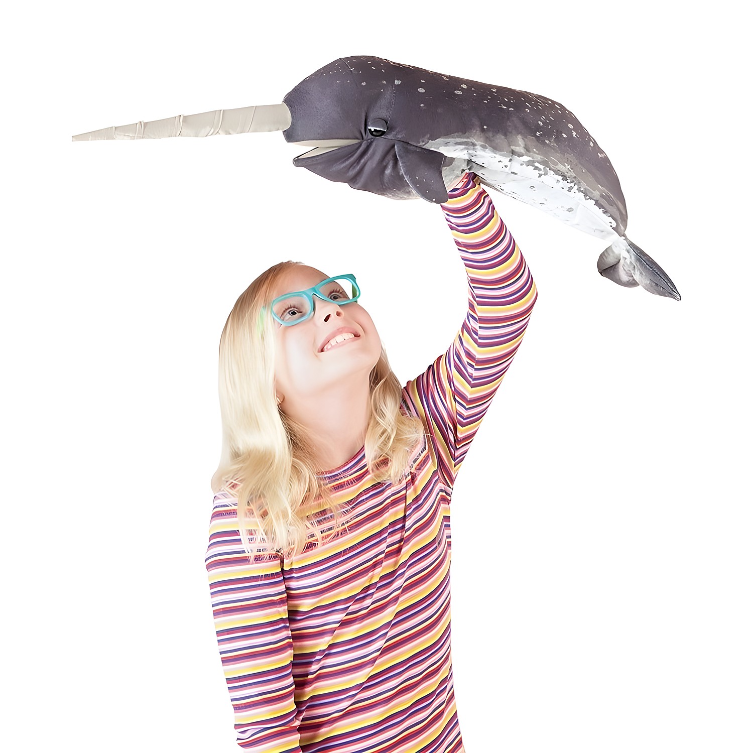 Girl holding a Folkmanis narwhal hand puppet with realistic fur print and long horn high above her head