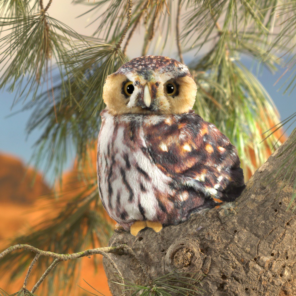 Folkmanis saw-whet owl hand puppet with brown spotted plumage sitting on a pine branch, front view