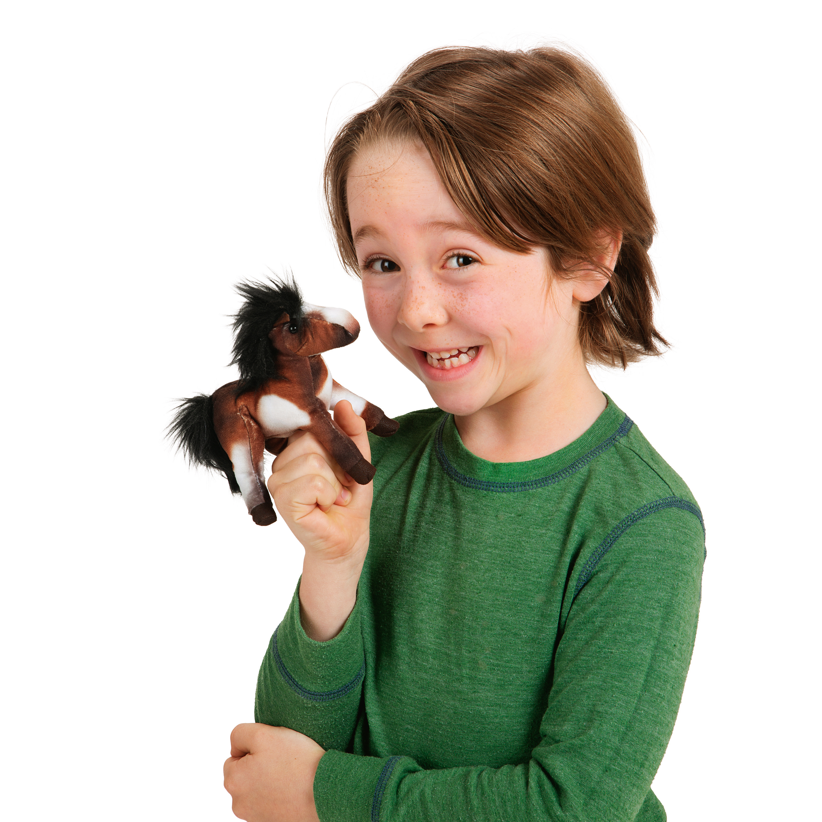 Smiling child holding a Folkmanis mini paint horse finger puppet in brown and white with a black mane on their index finger