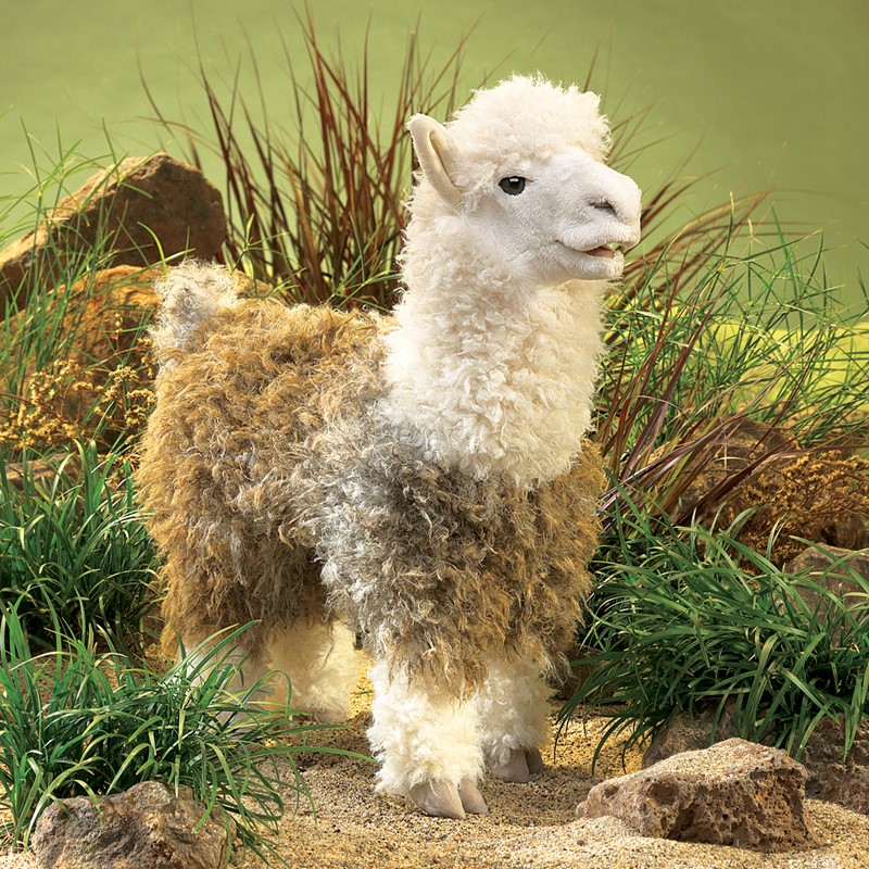 Folkmanis Handpuppe Alpaka mit lockigem weiß-beigem Fell in stehender Pose vor grünem Naturdiorama