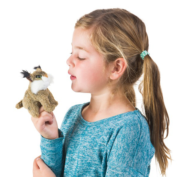 Mädchen trägt Folkmanis Fingerpuppe Mini-Rotluchs am Zeigefinger und pustet die kleine Plüschfigur an