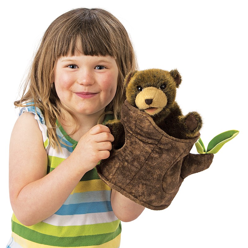Folkmanis hand puppet bear in tree stump: child holds a brown plush bear peeking out of a tree stump puppet cover with green leaves