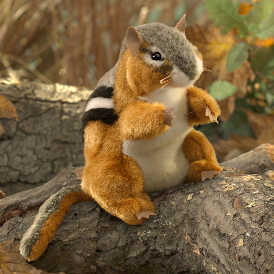 Folkmanis Handpuppe Streifenhörnchen mit rostbraunem Fell und charakteristischen schwarz-weißen Rückenstreifen, aufrecht auf einem Baumstamm sitzend