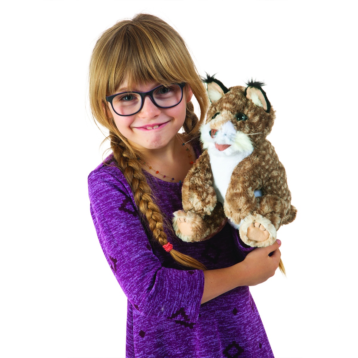 Mädchen mit Zöpfen hält die Folkmanis Handpuppe Rotluchs-Baby mit braun-gemustertem Fell und schwarzen Ohrpinseln in den Armen.
