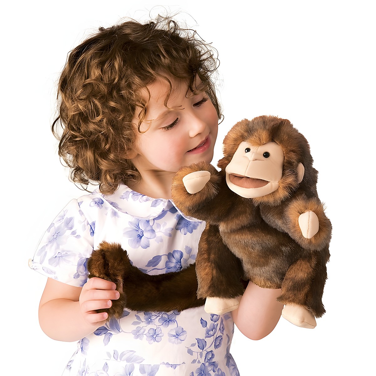 Girl wearing a brown Folkmanis monkey hand puppet with a movable mouth on her hand