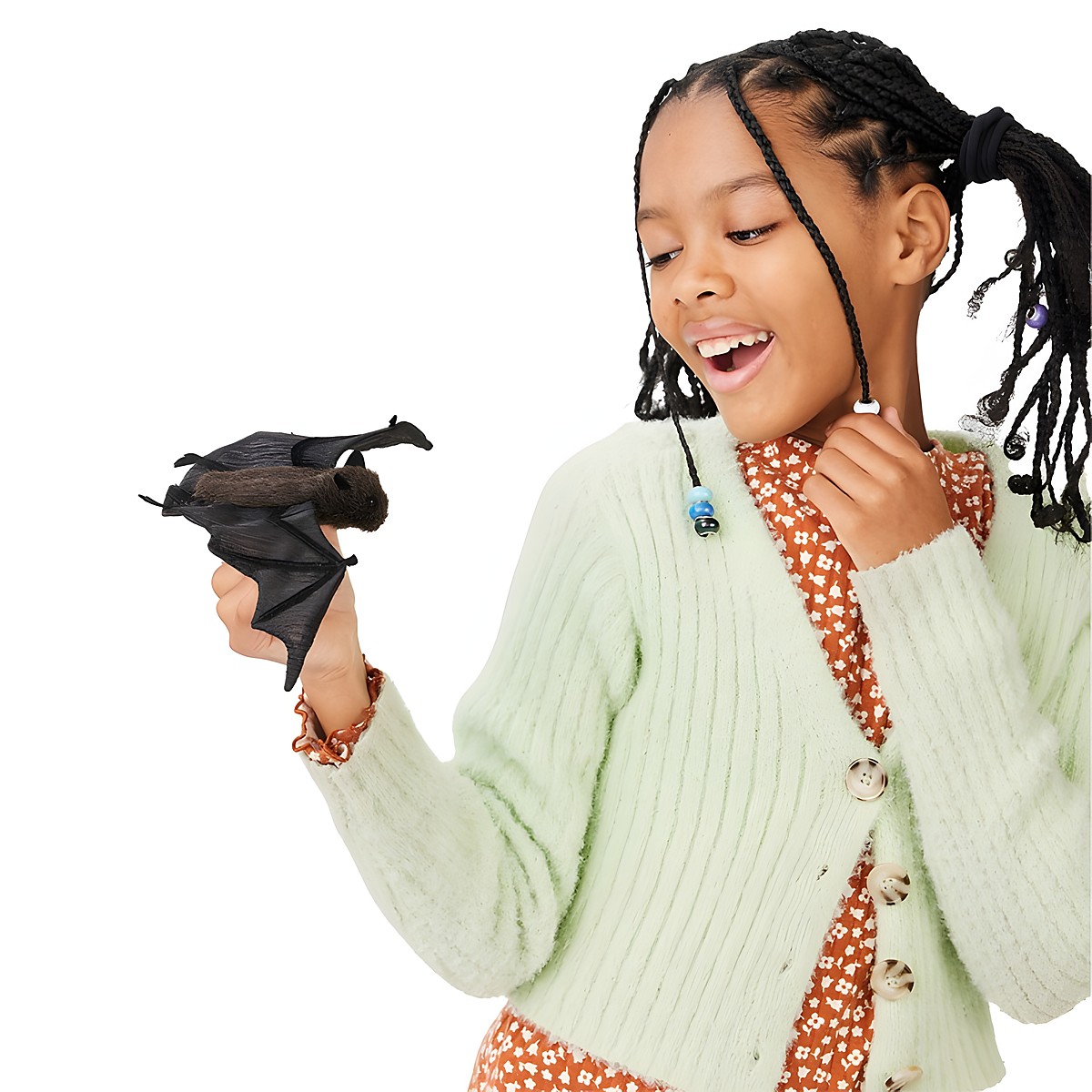 Girl holding a Folkmanis mini bat finger puppet in black with spread wings on her finger and laughing