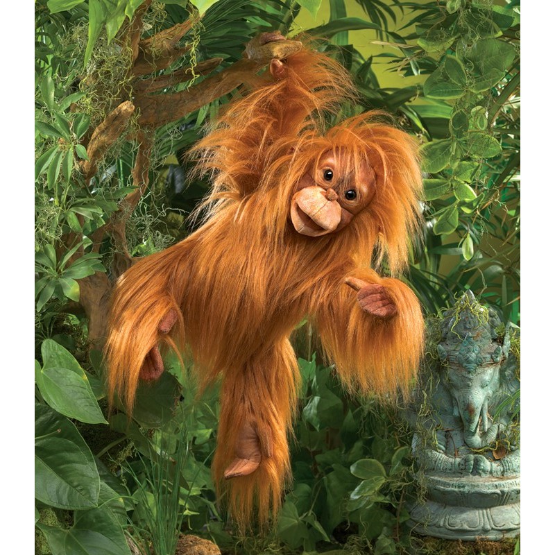 Folkmanis Handpuppe Baby Orang-Utan mit rotem Zottelfell, geöffnetem Mund und ausgestrecktem Arm vor grünem Dschungelhintergrund