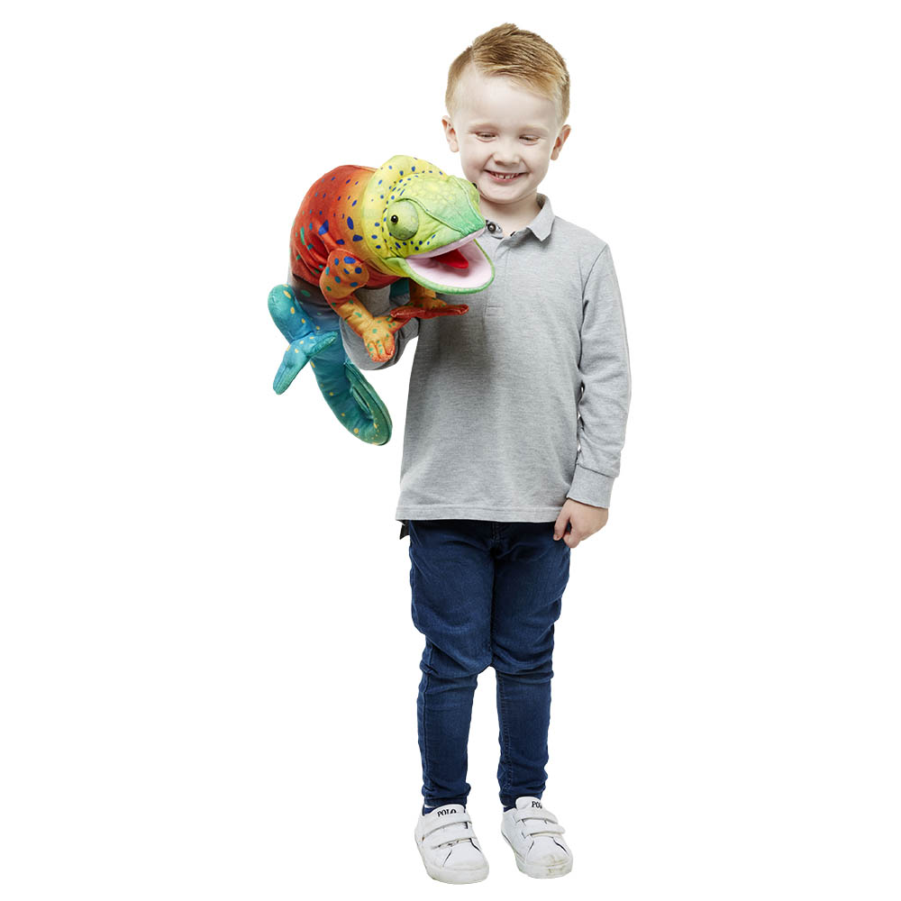 Smiling boy carrying the The Puppet Company large chameleon hand puppet, usage example