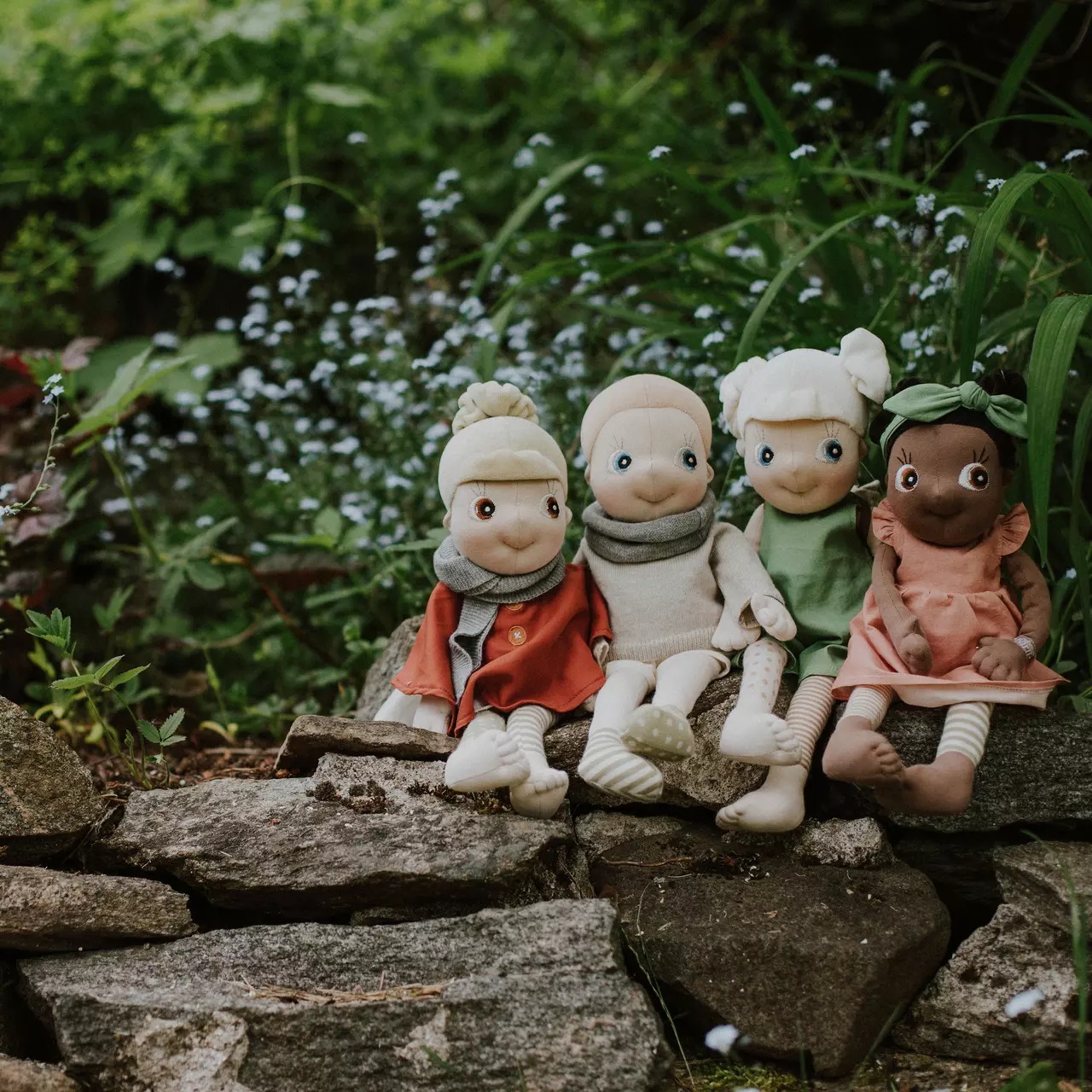 Die vier Rubens EcoBuds Puppen in Saison-Outfits auf der Gartenmauer, Winter in Beige