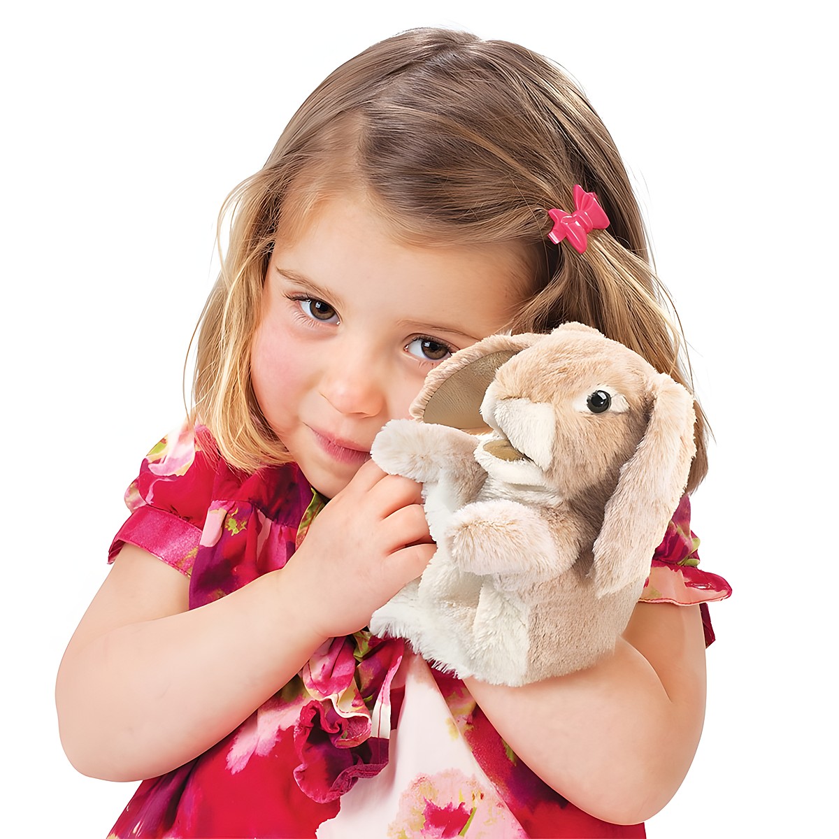 Mädchen hält Folkmanis Handpuppe kleines Widderkaninchen in beigem Plüsch mit langen Schlappohren an die Wange