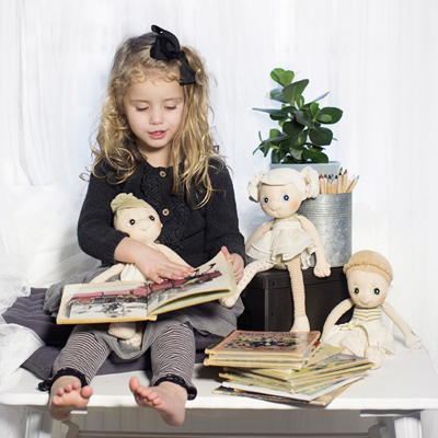 Child reading to the Rubens EcoBuds dolls, Daisy on their lap