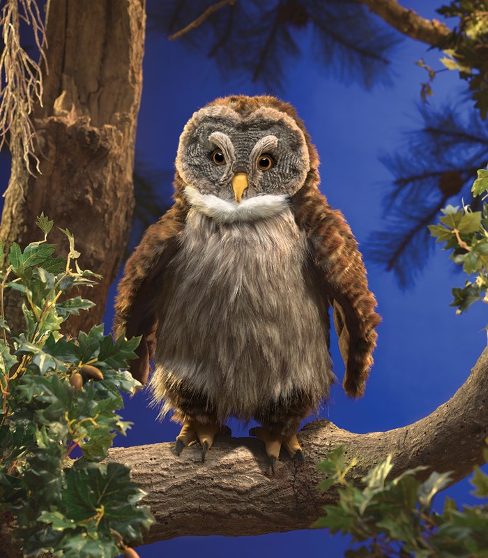 Folkmanis hand puppet owl with brown-grey plush plumage and a yellow beak, sitting frontally on a branch