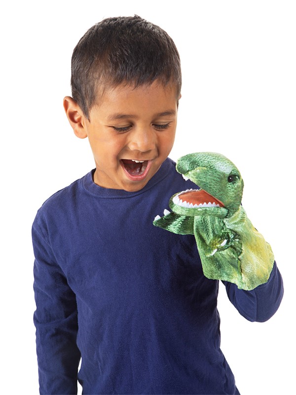 Laughing boy wearing a green Folkmanis Little T-Rex hand puppet with an open mouth and white teeth on his hand