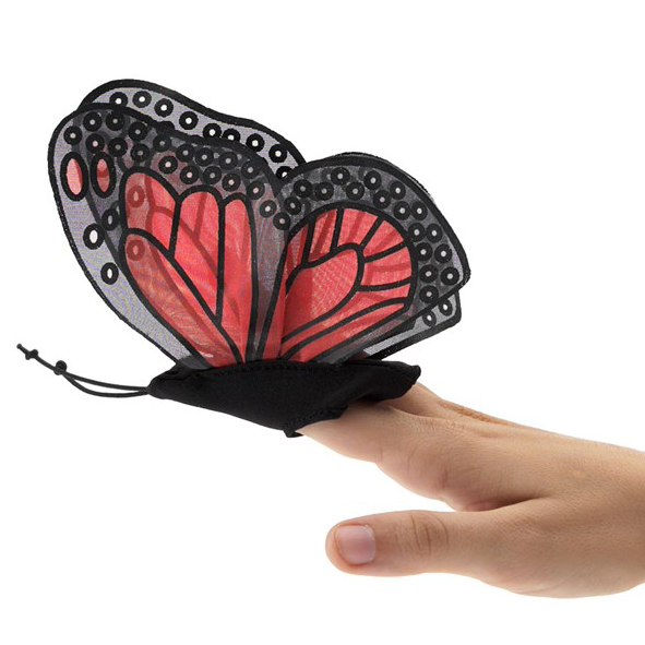 Folkmanis mini monarch butterfly finger puppet with red and black wings on an index finger, side view