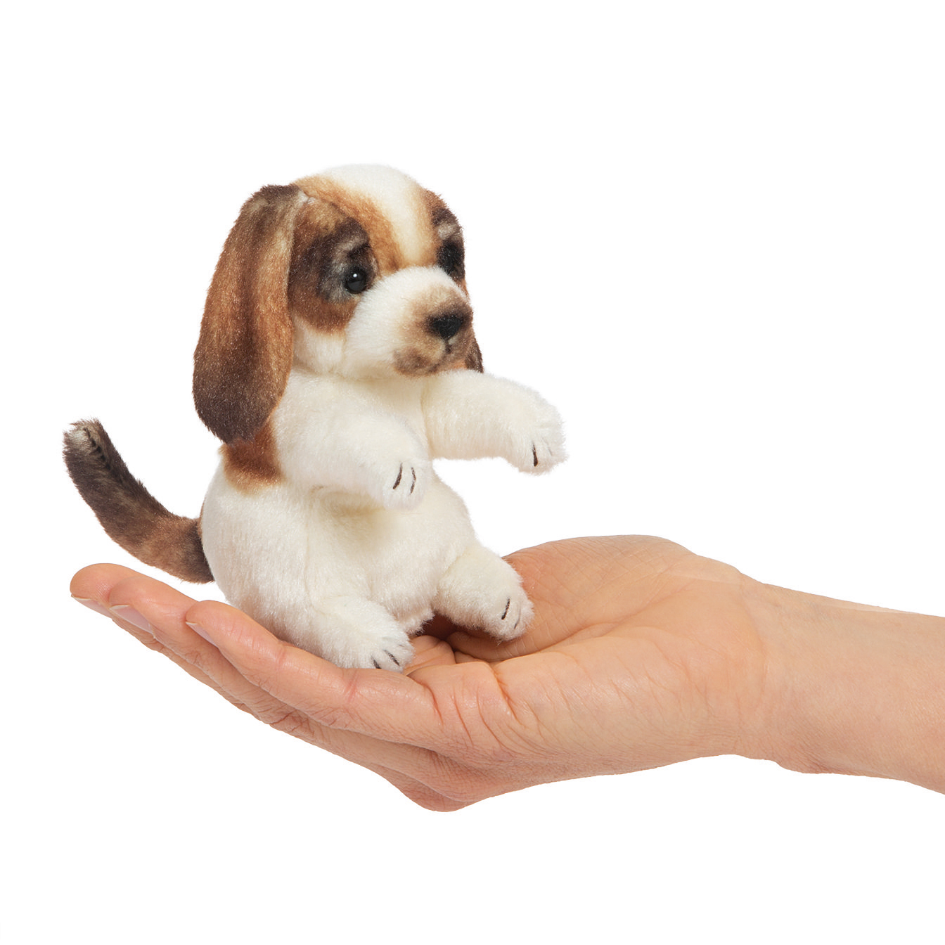 Folkmanis mini finger puppet dog in white and brown, sitting on a palm to show its tiny size
