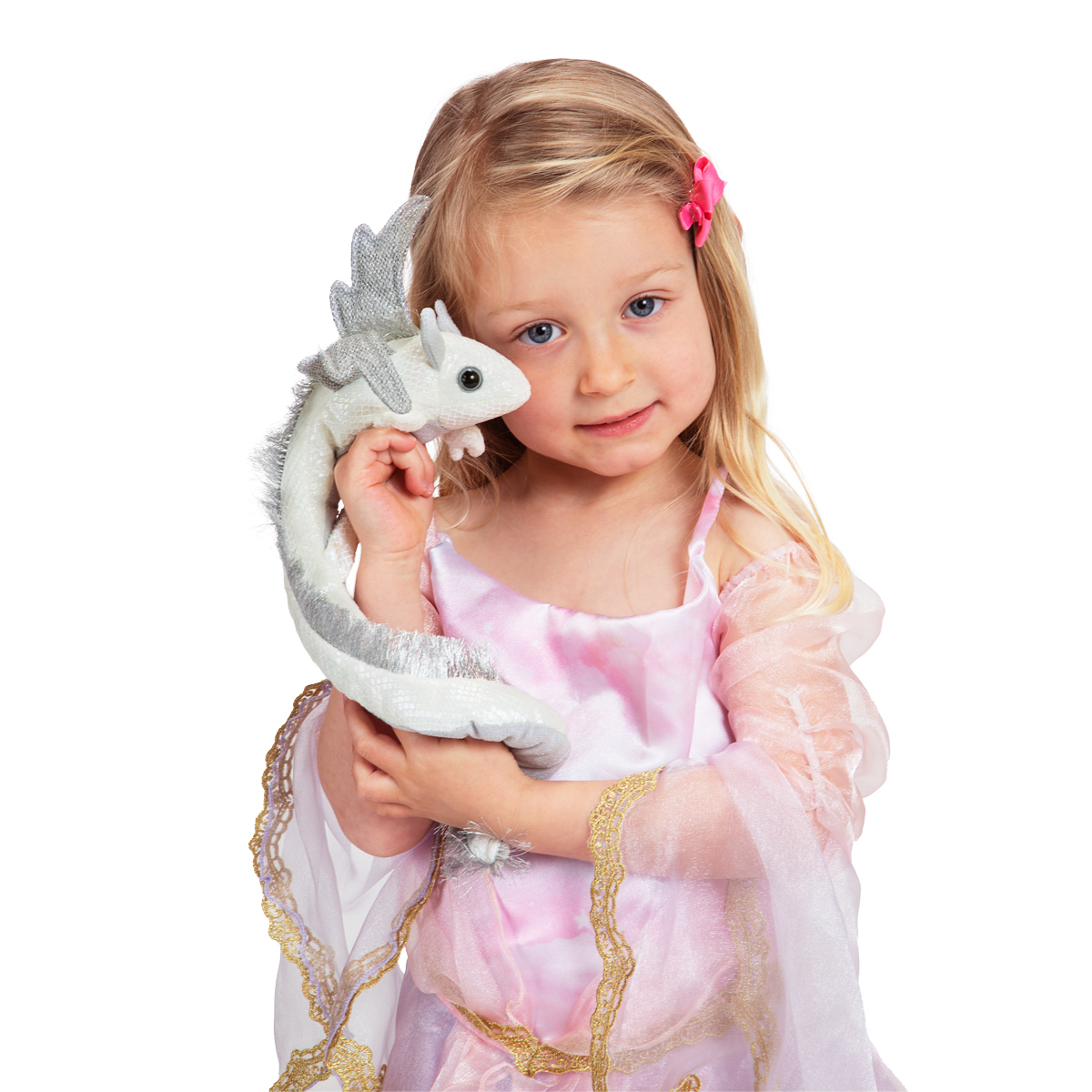 Girl in a pink princess costume holding a white Folkmanis dragon finger puppet with silver wings and a curly tail against her cheek