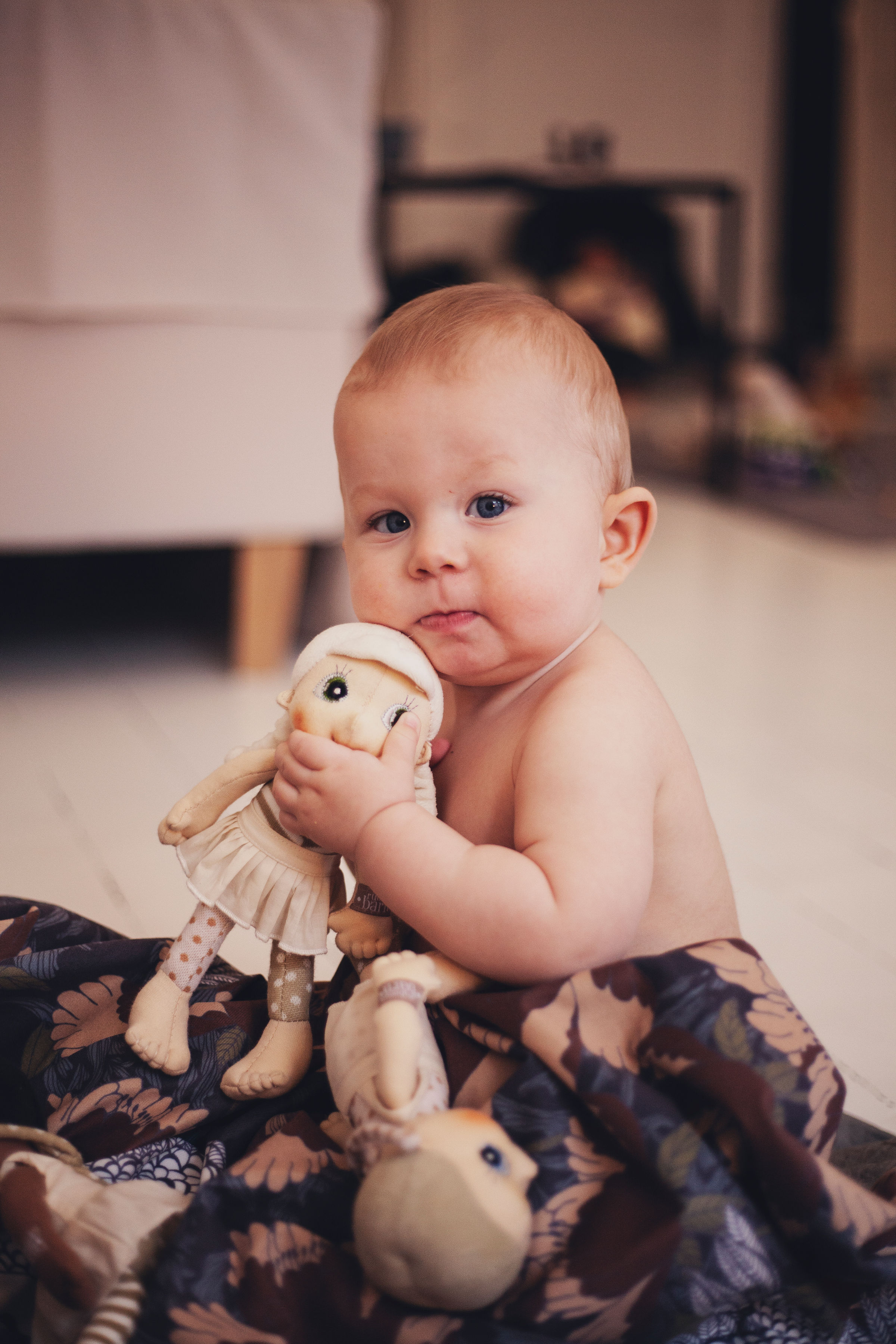 Baby hugging the Rubens EcoBuds mini doll Lily
