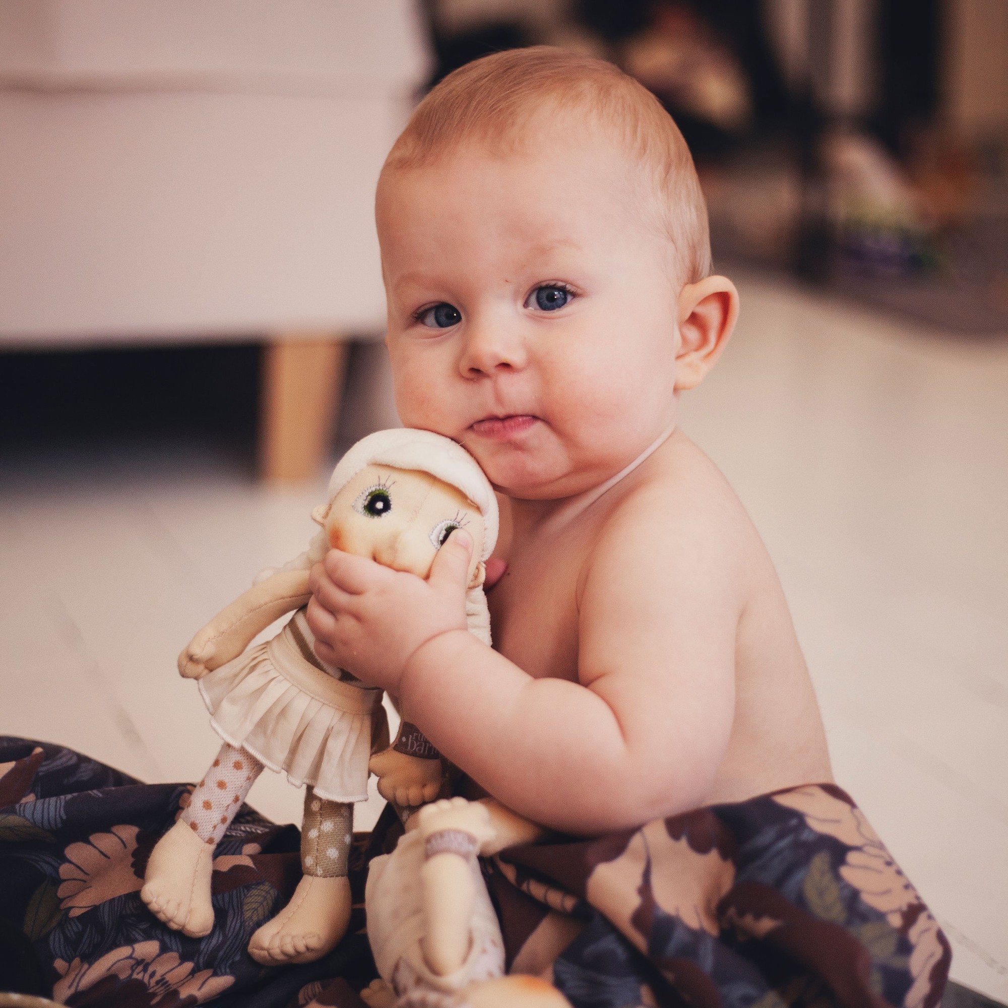 Baby hugging the Rubens EcoBuds mini doll Lily