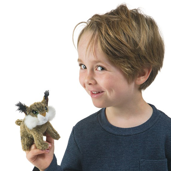 Lächelndes Kind hält kleine Folkmanis Fingerpuppe Mini-Rotluchs mit Pinselohren und weißem Bartbereich auf dem Zeigefinger.