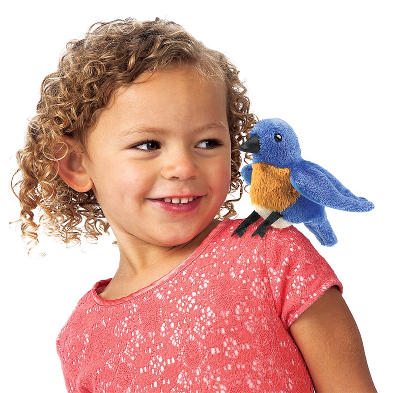 Folkmanis mini bluebird finger puppet in blue and orange sitting on the shoulder of a smiling girl