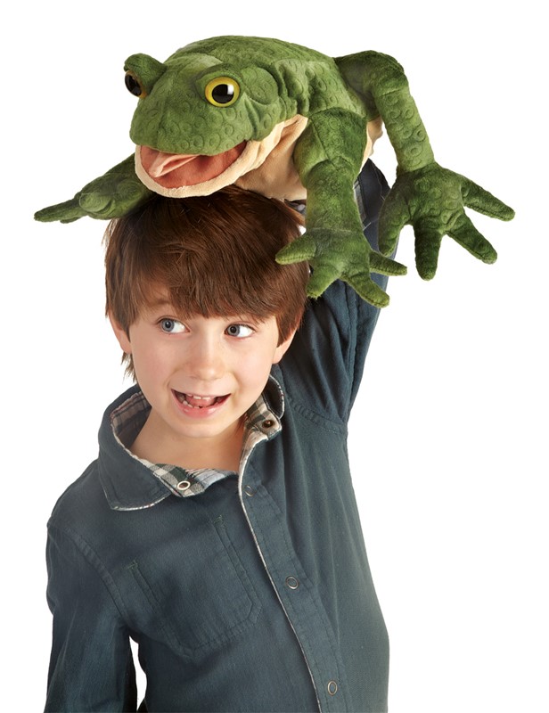 Laughing boy holding a Folkmanis toad hand puppet with an open mouth and green textured surface above his head