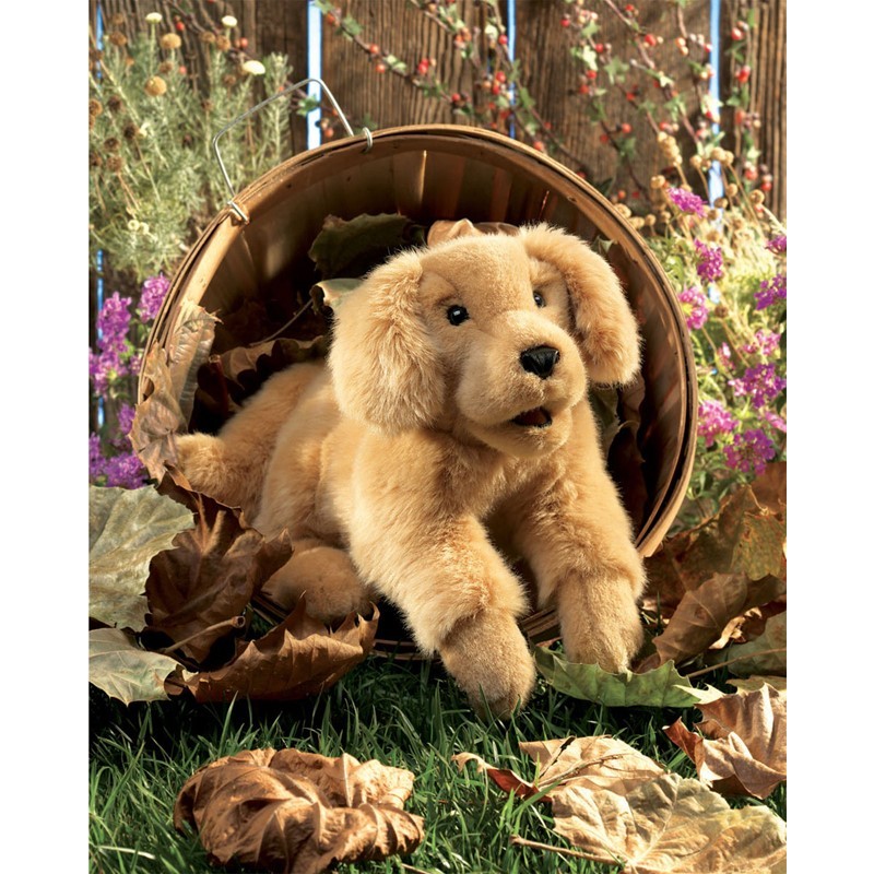 Folkmanis Golden Retriever puppy hand puppet in golden plush, peering out of a wicker basket surrounded by autumn leaves