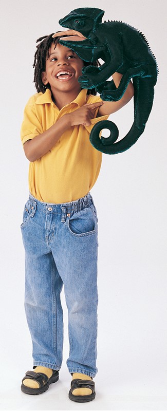 Laughing boy holding a large dark green Folkmanis chameleon hand puppet with a curled tail up in the air