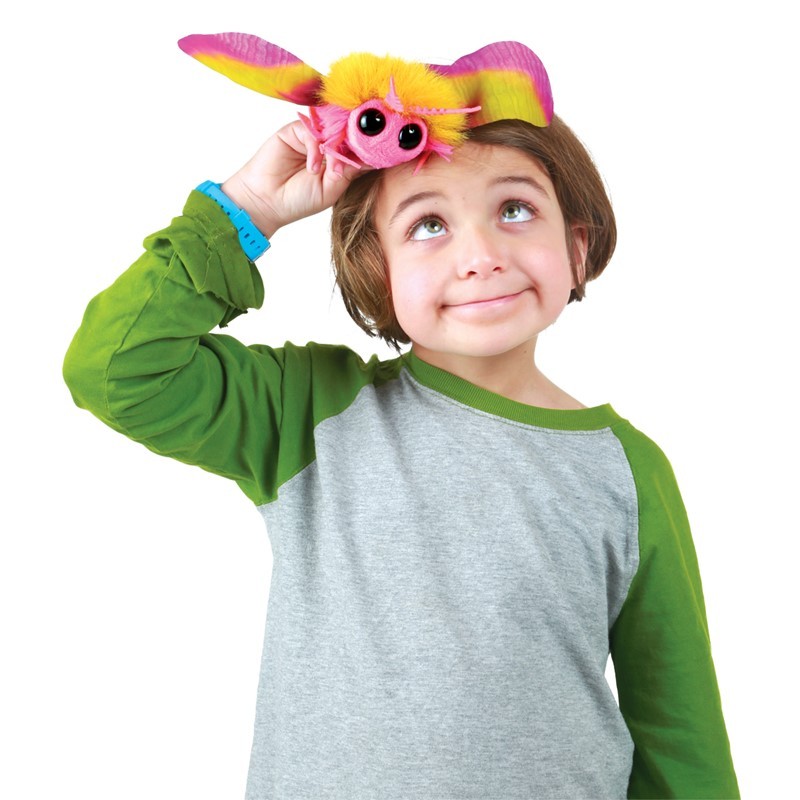 Folkmanis mini Rosy Maple Moth finger puppet in pink and yellow, balanced on a child's head, front view