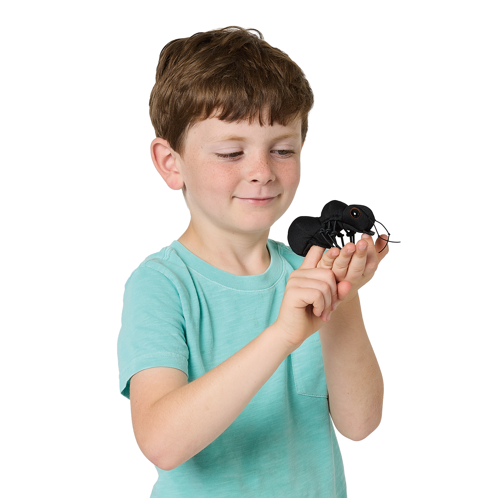 Junge hält schwarze Folkmanis Fingerpuppe mini Ameise auf den Fingern und schaut lächelnd darauf