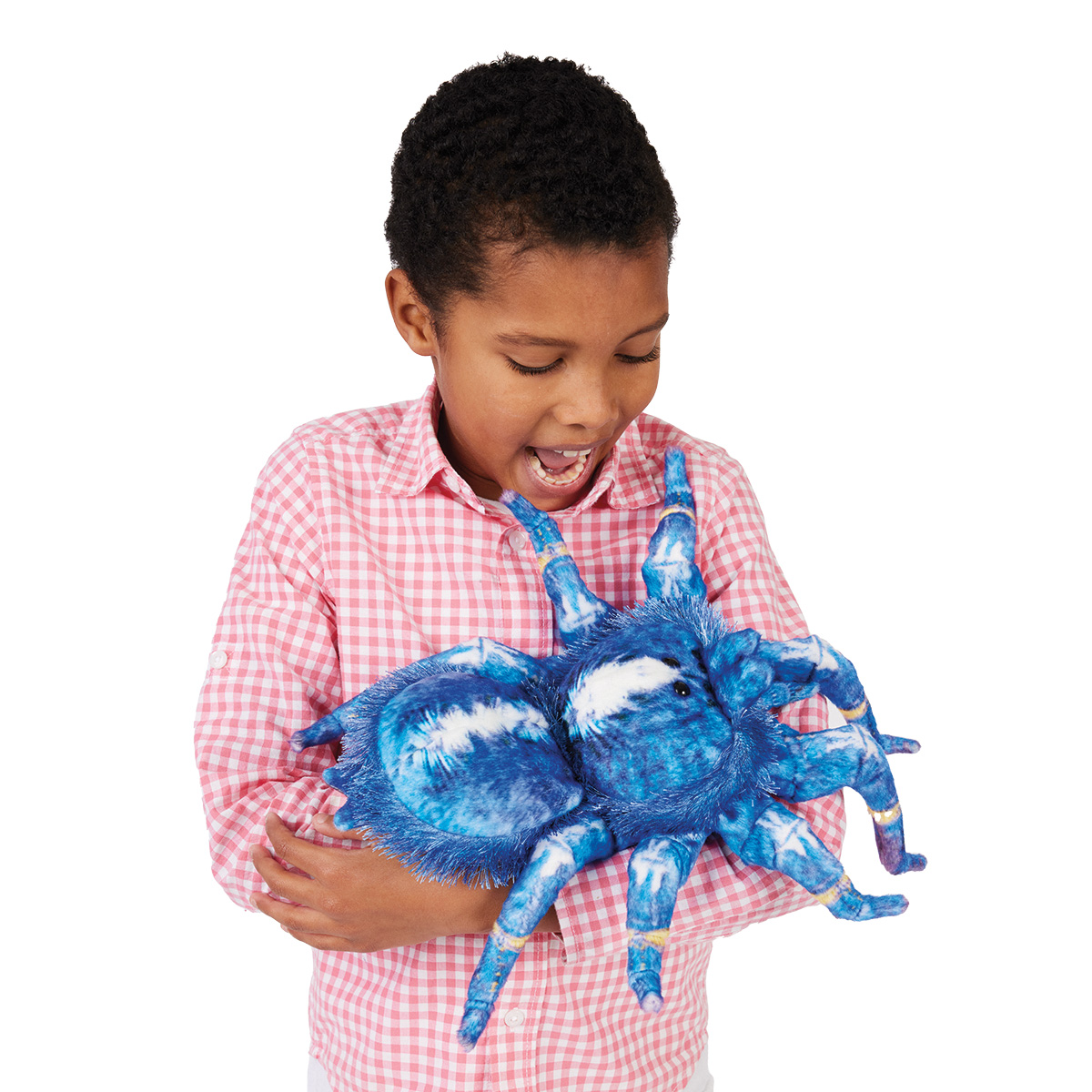 Kind hält Folkmanis Handpuppe Blaue Vogelspinne mit blau-weißem Plüschkörper und acht Beinen lachend in den Händen.