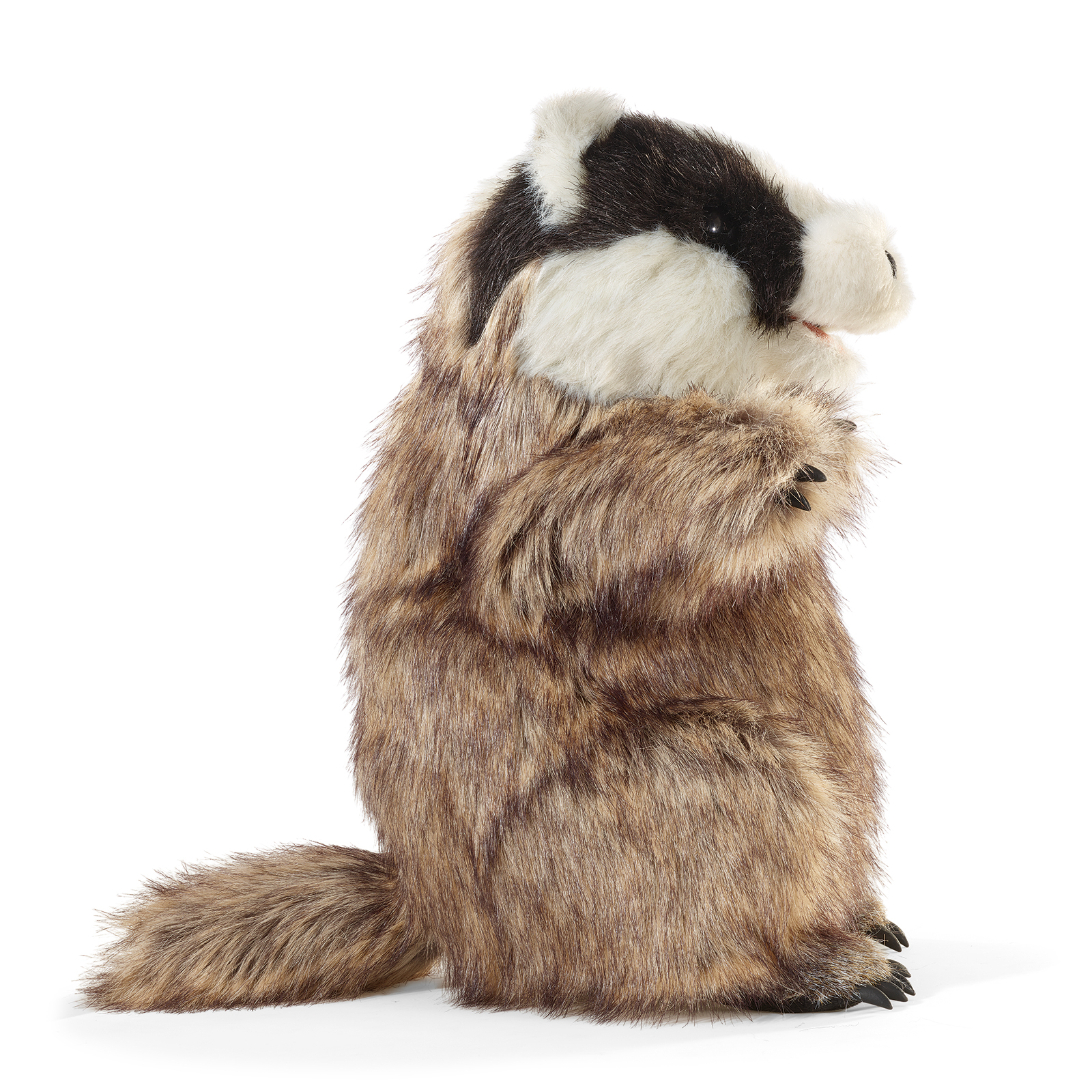 Folkmanis badger hand puppet shown side-on, with brownish-grey fur and its black-and-white marked head turned slightly towards the camera.