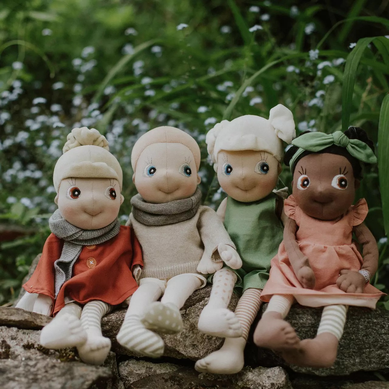 The four Rubens EcoBuds dolls on a garden wall, the summer outfit in pink