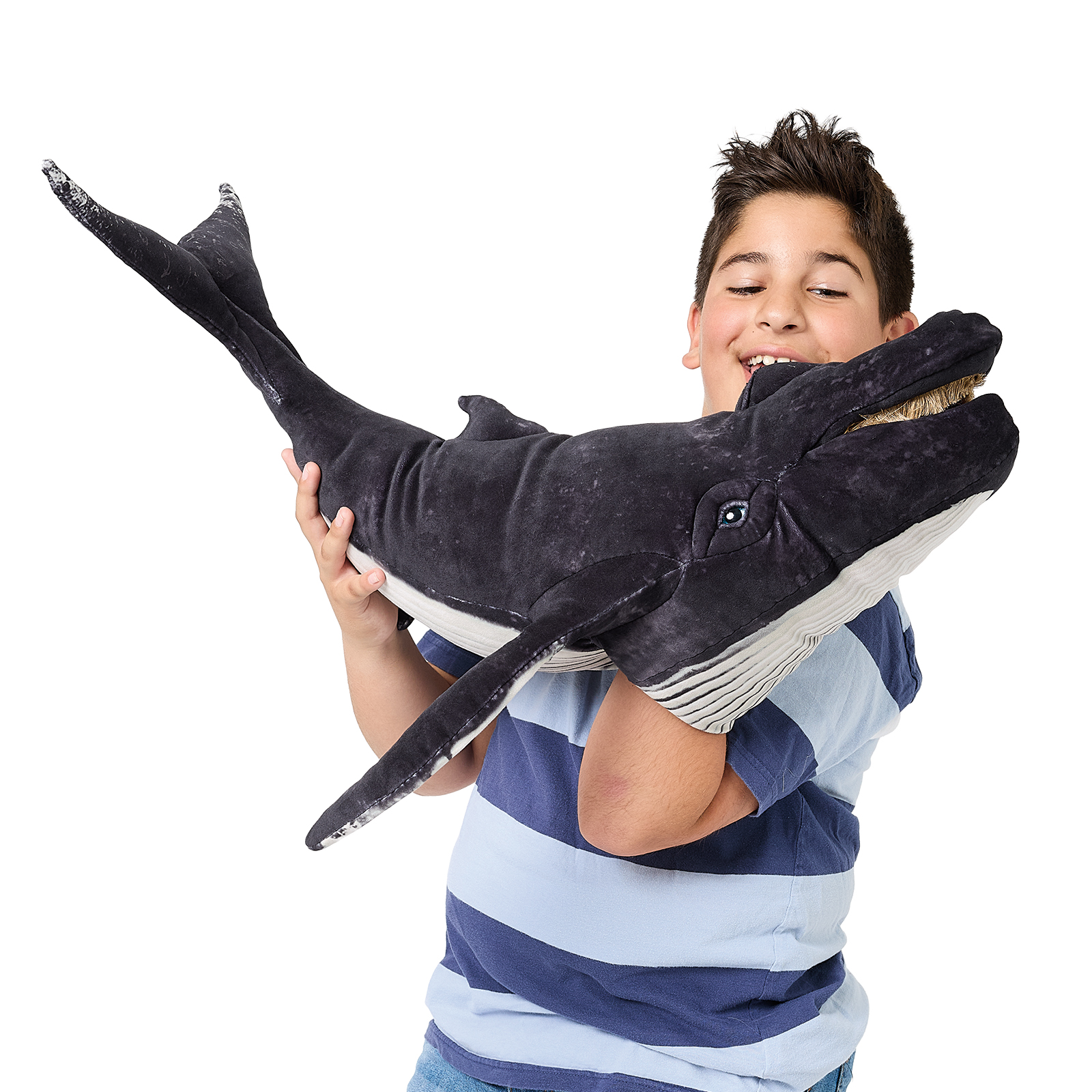 Boy holds large Folkmanis humpback whale hand puppet with dark grey back and light belly up in both arms