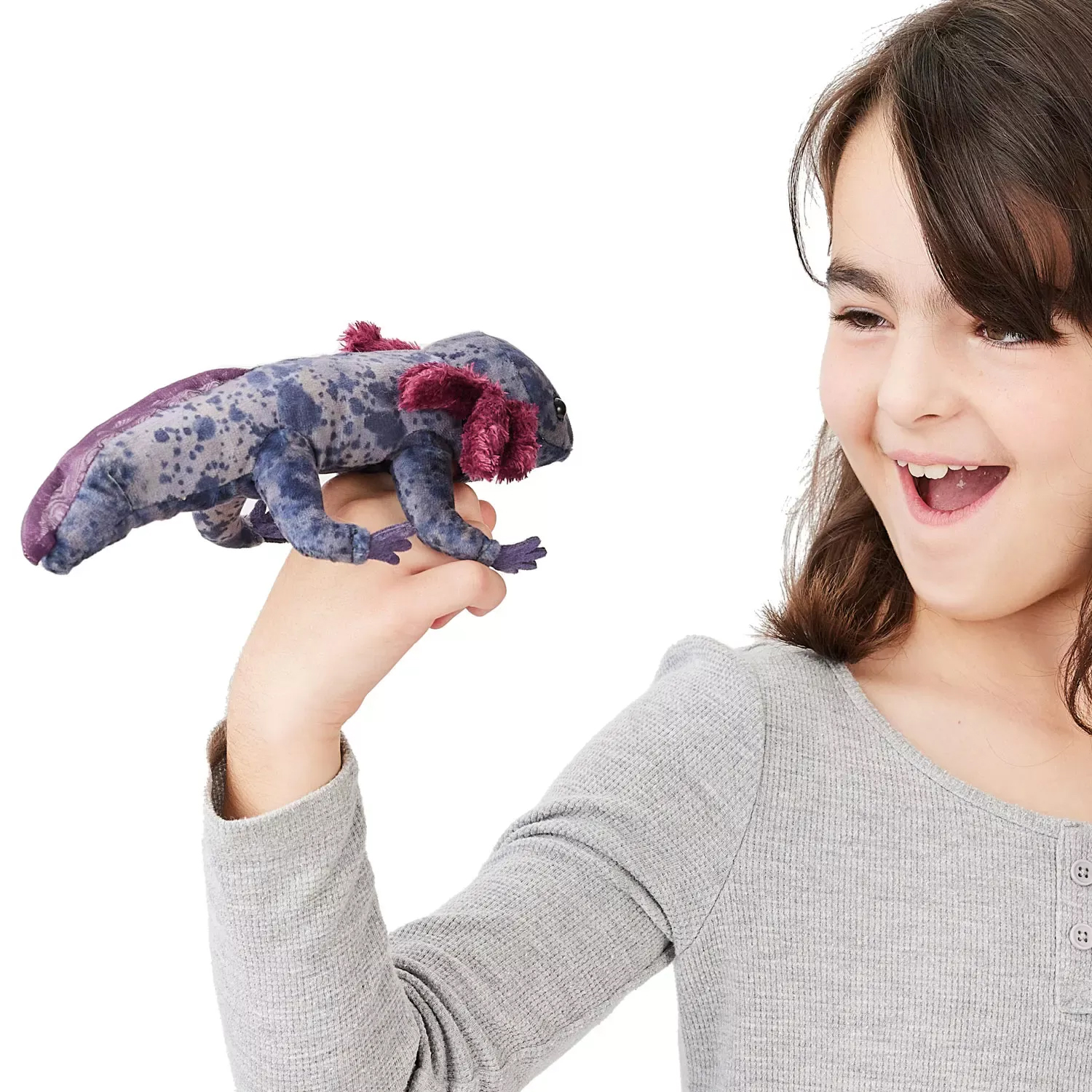 Folkmanis finger puppet Mexican axolotl in blue-grey with purple fins and pink gills on the outstretched finger of a laughing girl