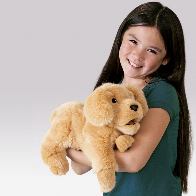 Mädchen hält Folkmanis Handpuppe Golden Retriever Welpe mit beweglichem Maul in goldfarbenem Plüsch im Arm