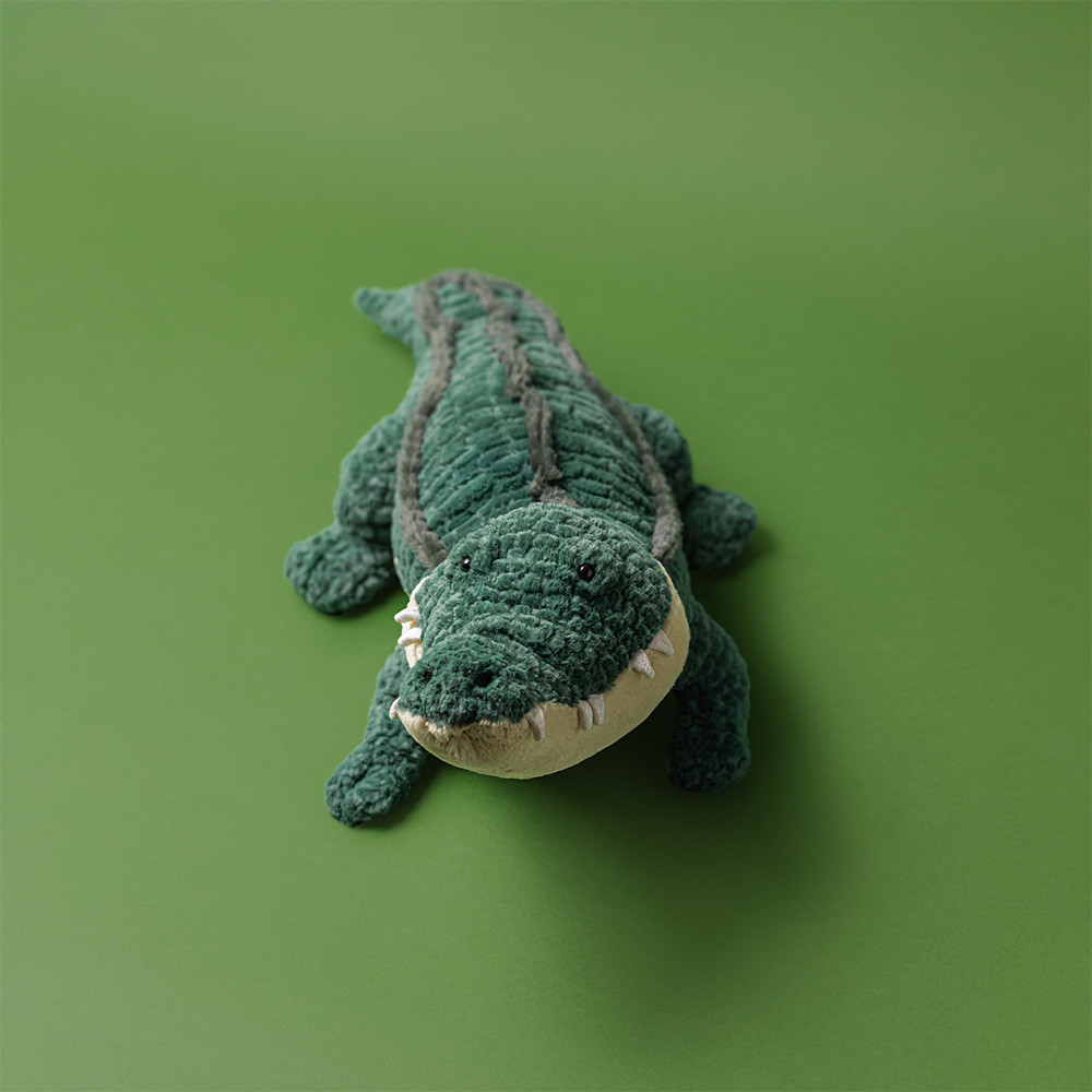 Jellycat plush toy alligator Allexi, top-down view of the green ribbed back fur against a green background