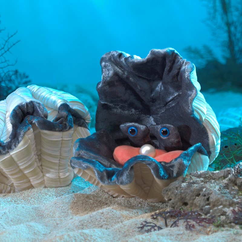 Folkmanis giant clam hand puppet in dark grey plush with blue eyes, pink tongue and white pearl, open against an underwater backdrop